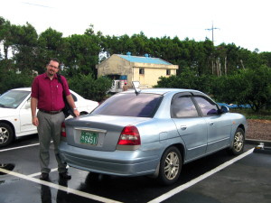 Patrick with the new (very used) car. Purple tinted windows and all!